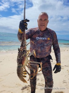 A snorkeler with his lobster catch. San Salvador Island, Bahamas.