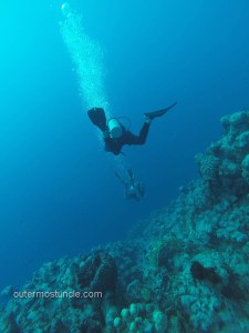 Modern day image of SCUBA divers, descending a coral reef wall. San Salvador Island, Bahamas.