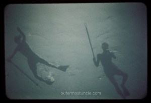Creepy Cold War era photo of two divers in the Bermuda Triangle with spear guns.  The photo is taken from below the sea in the Bermuda Triangle.