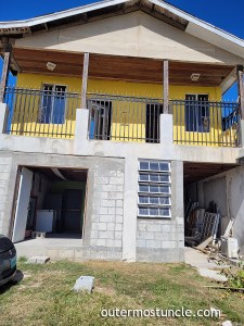 A big yellow building that is Char's Kitchen - a restaurant on San Salvador Island, Bahamas.