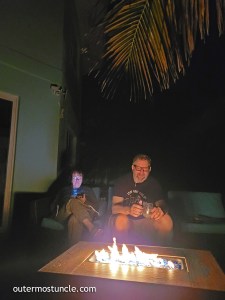 My cousin, John, and his wife, sitting on the deck at night. In front of a burning firepit. 