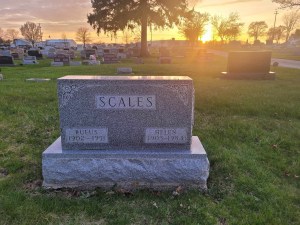 Sunset behind a gravestone that says , "Scales". Archbold, Ohio.