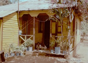 1950's photo of a Bahamian boy, relaxing on a front porch.