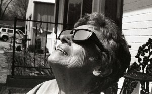 A woman, looking up, viewing the total eclipse while wearing protective eye gear.