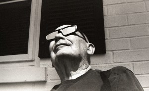 A man, looking up, viewing the total eclipse while wearing protective eye gear.