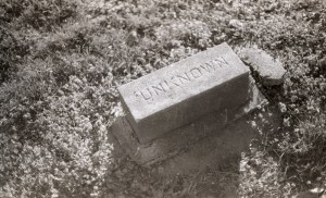 A black and white photo of a random gravestone that simlpy says "unknown".
