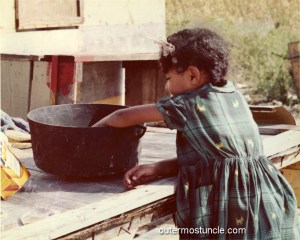 Bahamas girl, reaching into a pot.
