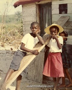 2 Bahamas island children in front of a home.