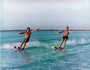 A color photograph of two young men, water skiing. 1950's
