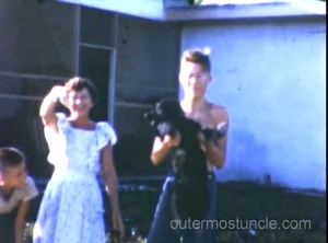 May, waving. Don holds up his dog, making it wave.