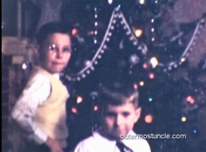 2 boys in front of a Christmas tree.
