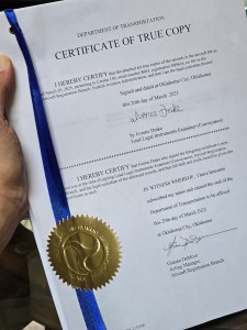 The stack of papers with a blue ribbon.