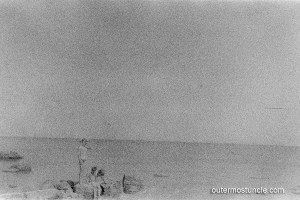 3 children on a rocky shore.